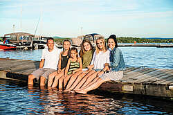 family sitting together on dock 