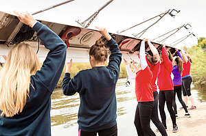 group of girls carrying a canoe